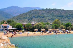 a beach with a bunch of people in the water at Studios on the Beach in Skala Sotiros