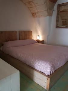um quarto com uma cama com uma estrutura em madeira em Casetta del Pescatore em Polignano a Mare