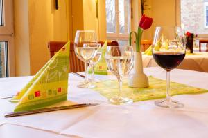 a table with three glasses of wine on it at Quick Hotel Dresden West in Kesselsdorf