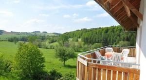 a balcony with chairs and a view of a green field at Rhön-Hotel Sonnenhof - Restaurant & Café in Poppenhausen