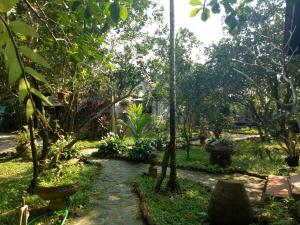 a garden with trees and a path at Tam Tinh Vien Homestay in Hue