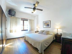 - une chambre avec un lit et un ventilateur de plafond dans l'établissement Hotel Imperio, à Mar del Plata