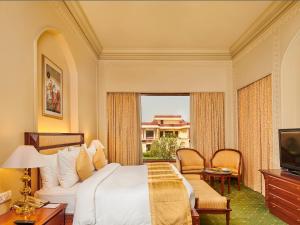 a bedroom with a bed and a large window at The Ummed Jodhpur Palace Resort & Spa in Jodhpur