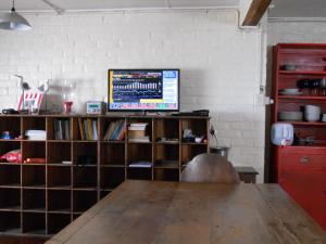 布菲尔斯巴埃Sailaway Beach House的房间里有一张桌子和一台挂在墙上的电视