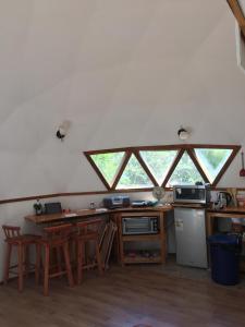 una cocina con 2 ventanas y una barra con taburetes en Domos de Molco, en Pucón