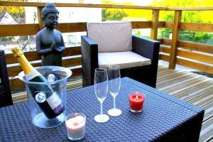 un tavolo con bicchieri, una bottiglia di vino e una statua di dampierrelove a Dampierre-les-Bois
