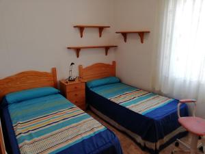 a bedroom with two beds and a desk and a window at Delfines Solo Familias Serviplaya in Playa de Xeraco +93 photos