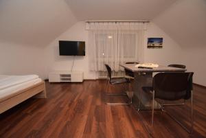 a bedroom with a bed and a desk and chairs at Apartment Ostfildern-Nellingen II in Ostfildern