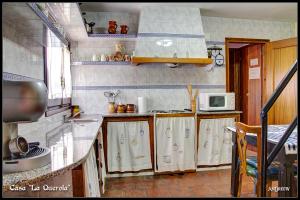 a kitchen with a sink and a microwave at Casa La Querola in Morella