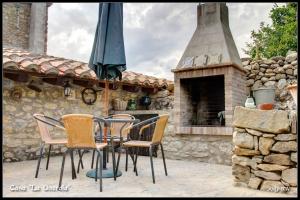 un patio con mesa, sillas y chimenea en Casa La Querola en Morella