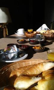 una mesa con platos de pan y tazones de comida en Hostería Rural Les Aldudes en San Andrés de Giles