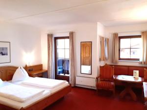 sypialnia z dwoma łóżkami, stołem i krzesłem w obiekcie All Inclusive - Marco Polo Alpina Familien- & Sporthotel w mieście Maria Alm am Steinernen Meer