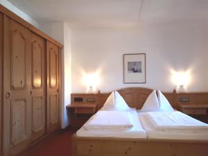 a bedroom with two beds and two night stands at Marco Polo Alpina Familien- & Sporthotel in Maria Alm am Steinernen Meer