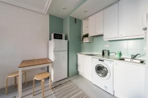 マドリードにあるSuper View Apartment Plaza Mayorのキッチン(白いキャビネット、洗濯機、乾燥機付)