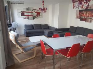 a living room with a white table and red chairs at Meublés de Tourisme à Vincennes in Vincennes