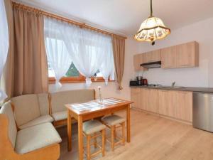 a living room with a table and a kitchen at Nad Strumyczkiem - pokoje gościnne - Apartamenty z przymróżeniem oka in Szczyrk