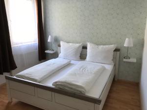 a large bed with white sheets and pillows at Ferienwohnung Nr.1 in Hollenstein an der Ybbs