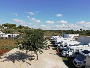 a row of parked vehicles in a parking lot at Sosta Camper La Specchia in San Pietro in Bevagna