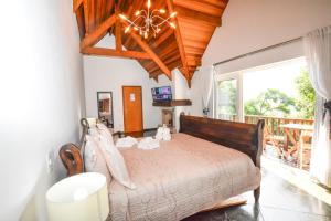 a bedroom with a bed and a large window at La Réserve Suites in Monte Verde