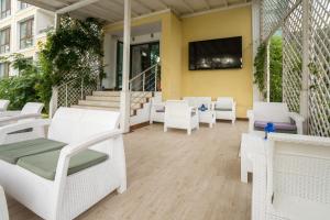 a patio with white chairs and a flat screen tv at Perla Royal Hotel - All Inclusive in Primorsko