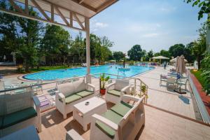 プリモルスコにあるPerla Royal Hotel - All Inclusiveのプールの景色を望む客室で、椅子とテーブルが備わります。