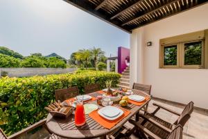 een houten tafel en stoelen op een patio bij Filerimos Oasis Luxury Villa in Ialyssos
