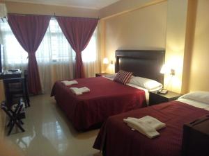 a hotel room with two beds with towels on them at Hotel Le Park in San Miguel de Tucumán