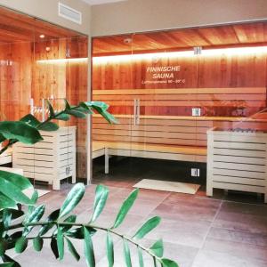 a spa room with a bench and a plant at Tauernsuites Mitterwirt by ALPS RESORTS in Piesendorf