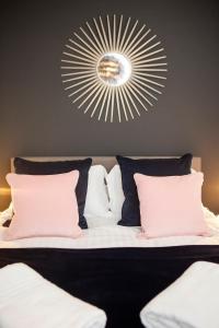 una camera da letto con letto, cuscini rosa e specchio di Apartment 5 Blue Bridge Court a York