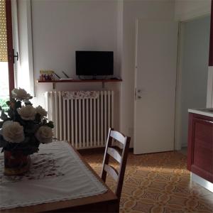 - un salon avec une table, des chaises et une télévision dans l'établissement Azzurramare Bed & Breakfast, à Grottammare
