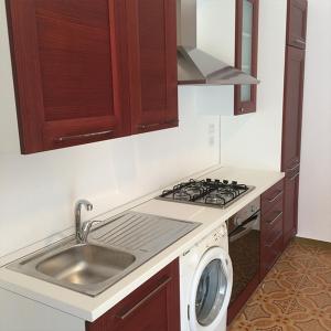 a kitchen with a sink and a washing machine at Azzurramare Bed & Breakfast in Grottammare