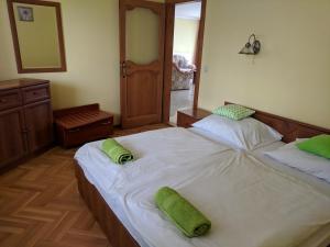 a bedroom with two beds with green pillows on them at Club Unicum in Hévíz