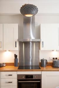 cocina con fogones de acero inoxidable horno superior en Apartment 5 Blue Bridge Court en York