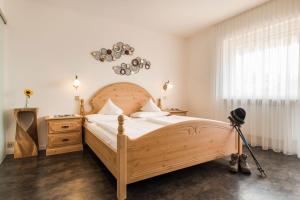 a bedroom with a wooden bed and a telescope at Pension Monika in Lagundo