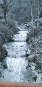 una corriente de agua con nieve en el suelo en La mansarda sul fiume, en Abetone