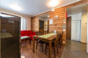 ein Esszimmer mit einem Tisch und einem roten Sofa in der Unterkunft Villa Ylläs 102 in Ylläsjärvi