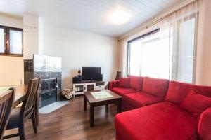 ein Wohnzimmer mit einem roten Sofa und einem Tisch in der Unterkunft Villa Ylläs 102 in Ylläsjärvi
