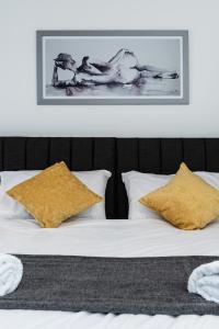 łóżko z dwoma poduszkami i zdjęciem na ścianie w obiekcie Milton House w mieście Plymouth