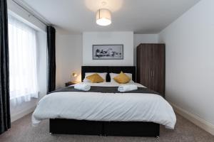 sypialnia z dużym łóżkiem z żółtymi poduszkami w obiekcie Milton House w mieście Plymouth