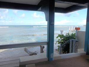 Blick auf den Strand von einem Fenster des Hauses in der Unterkunft Calibishie Sandbar in Calibishie