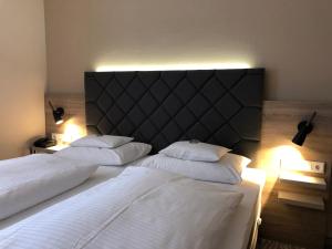 a bedroom with two beds with white sheets and lights at Villa Huxori in Höxter