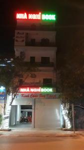 a building with a neon sign on top of it at Nhà nghỉ Book in Hoàn Giáp