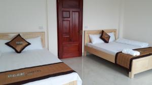 2 camas en una habitación con puerta roja en Nhà nghỉ Book, en Hoàn Giáp