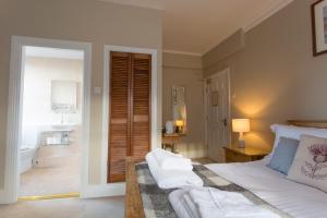 a bedroom with a bed and a bathroom with a sink at The Wheatsheaf Hotel in Corbridge