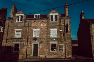 an old brick building with a sign on it at The Wheatsheaf Hotel in Corbridge