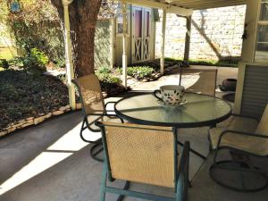 a table and chairs on a patio with a cup on it at Studio B Guest House in Fredericksburg