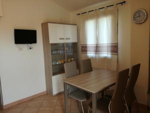 ein Esszimmer mit einem Tisch, Stühlen und einer Uhr in der Unterkunft Apartment Altomare in Cala Gonone