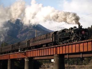 um comboio numa ponte com fumo a chegar em Wakihonjin em Kikugawa
