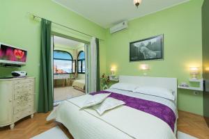 a bedroom with a large bed and a balcony at Villa Palma Apartments in Makarska