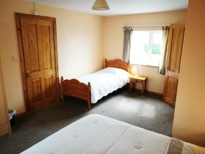 una camera da letto con due letti e una finestra di Danubio Guest Accommodation a Doonbeg